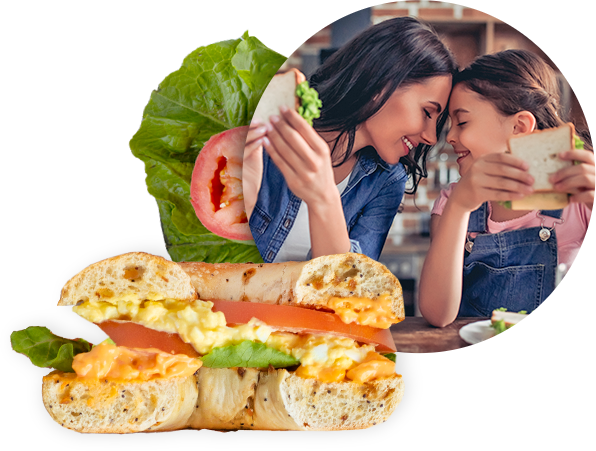 two girls touching foreheads and eating sandwiches with prices cheese.